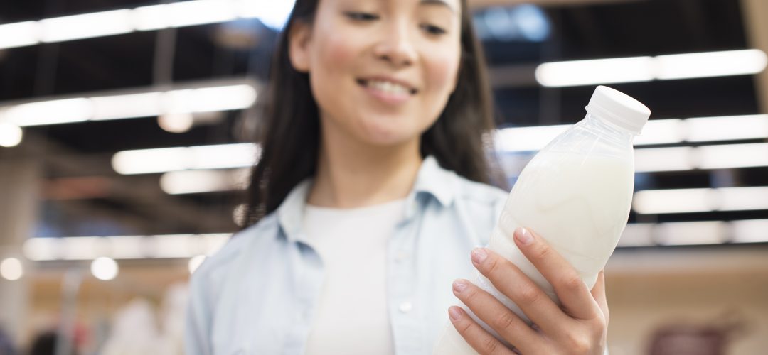 femme tenant une bouteille de lait entier ou demi-écrémé